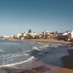 Beautiful coastal view of a sandy beach in Sicily, Italy under a clear blue sky.